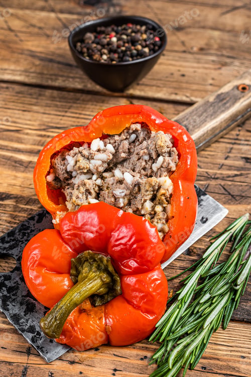 Preview: Roasted sweet bell pepper with meat, rice and vegetables. wooden background. Top view