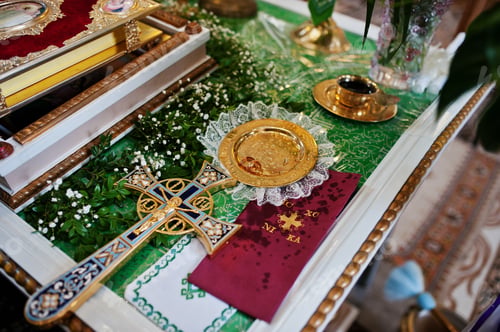 Preview: Wedding rings at discus with cross at church.