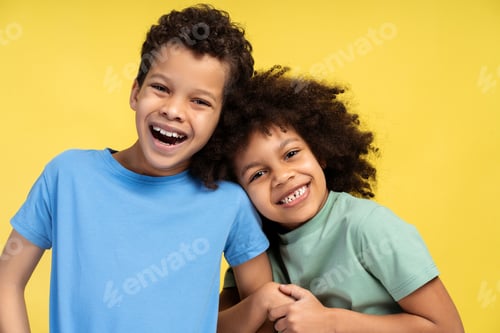 Preview: Little cite girl hugging boy while posing in studio, looking at camera. Friendship concept