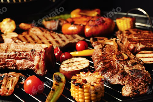 Preview: Fresh grilled meat steaks and vegetables on barbecue grate, closeup