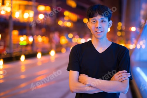 Preview: Portrait Of Asian Man Smiling Outdoors At Night