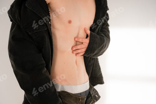 Preview: a young guy holds a hand to a thinned belly, a man has lost a lot of weight, a skinny physique