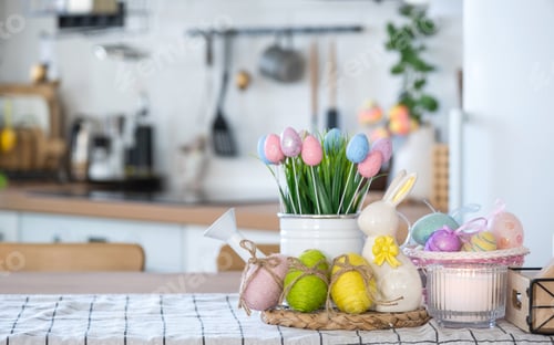 Preview: Easter decoration of colorful eggs in a basket and a rabbit on the kitchen table