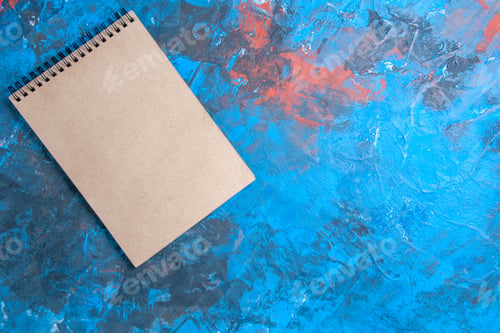 Preview: top view a notebook on blue background with copy space