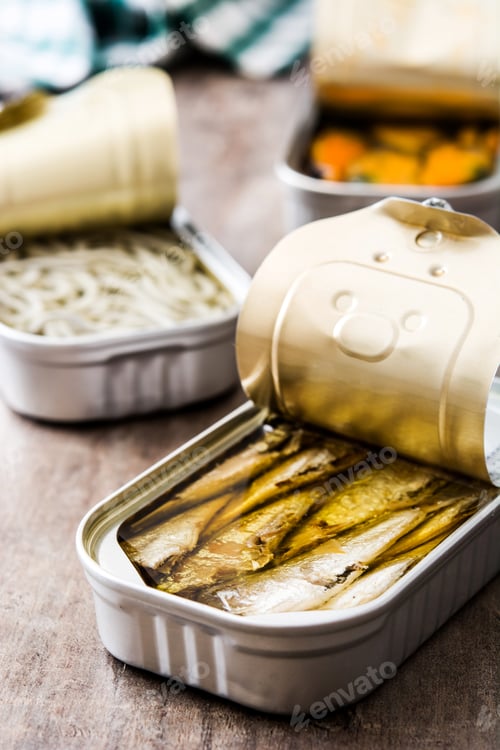 Preview: Open can of sprats in oil with other preserved fish in background