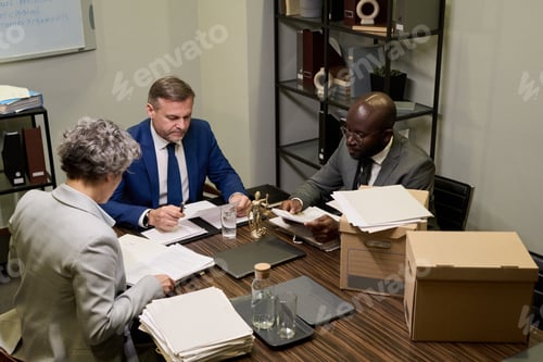 Preview: Middle Aged Caucasian Woman and Men Reviewing Legal Documents in Office Meeting