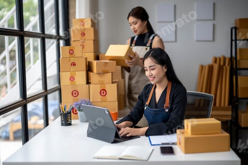 Preview: Two women are working in a warehouse, one of them is typing on a laptop