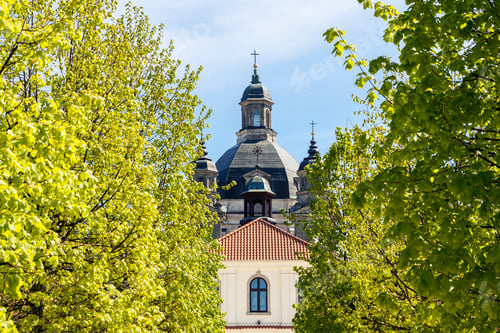 Preview: Baroque monastery through green trees