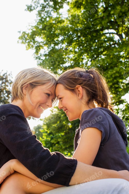 Preview: Warm moment between a mother and daughter sharing a loving gaze outdoors.