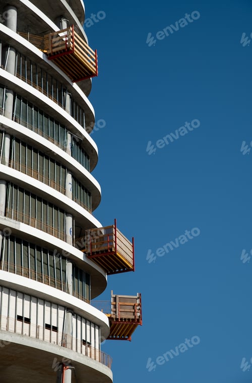 Preview: Residential office building construction site and cranes during a vibrant summer day with blue sky