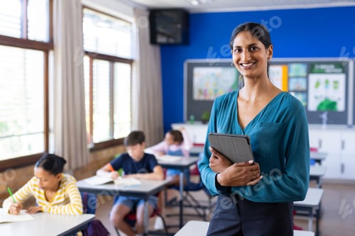 Visualização: Na sala de aula da escola, segurando um tablet, professora indiana sorridente com alunos, espaço de cópia
