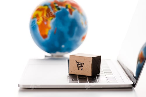 Preview: selective focus of toy box on laptop keyboard near globe isolated on white, e-commerce concept
