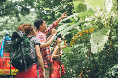 Preview: hikers looking at map. Couple or friends navigating together smiling happy during camping.