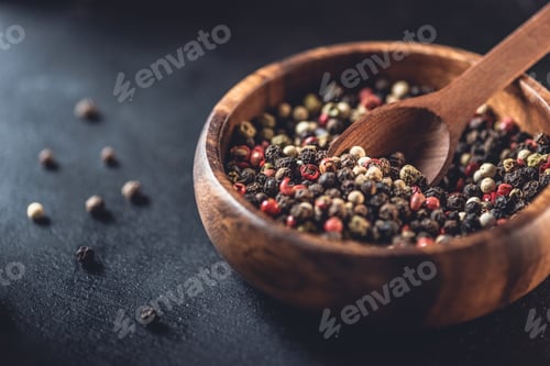 Preview: close-up view of wooden bowl and spoon with dried aromatic peppercorns on black