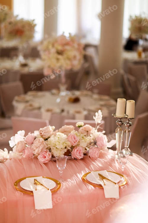 Preview: table decoration with pink tablecloth, crystal candlesticks with candles and white pink flowers in r