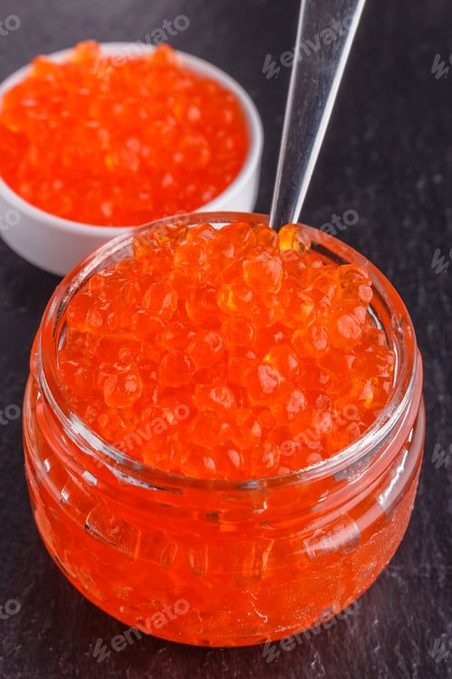 Preview: red caviar in a bowl on a dark stone background