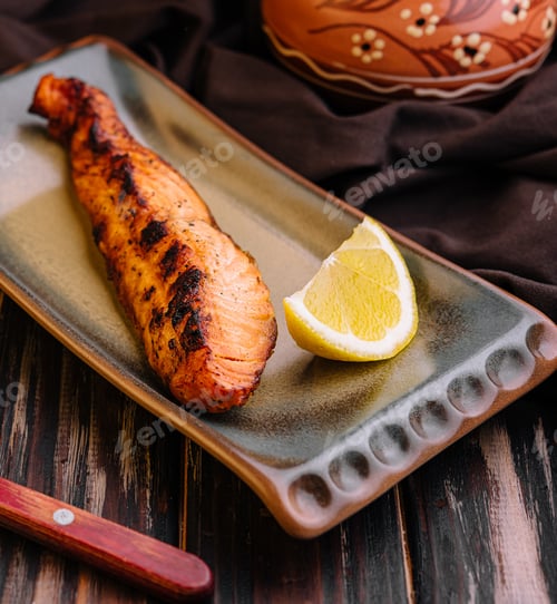 Preview: Grilled salmon fillet garnished with lemon and chili sauce