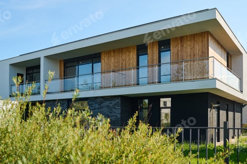 Preview: Side view of two storey cottage with windows and balcony on second floor