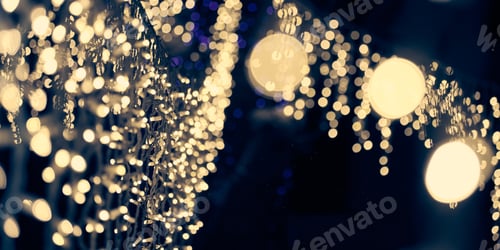 Preview: Pale yellow lights bokeh from christmas holiday garlands, blurred festive abstract background lights