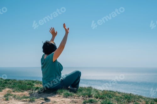 Preview: adult woman listens to music, podcast in headphones against backdrop of mountains, ocean and dance