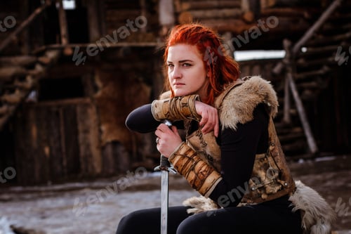 Preview: Red-haired woman is a Viking. Against backdrop of a village or an ancient settlement