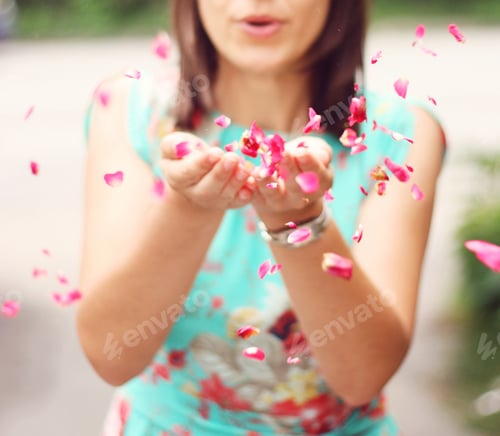 Preview: Woman blowing red rose petals