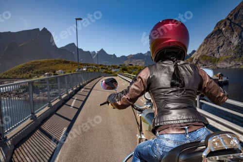 Preview: Biker girl rides on road in Norway.