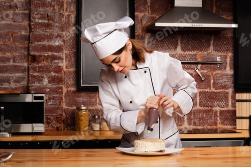 Preview: Female chef cook preparing a sweet cake in the kitchen