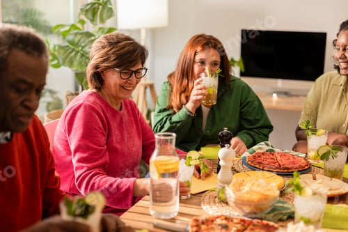Preview: Diverse group of people enjoying food and drinks at home