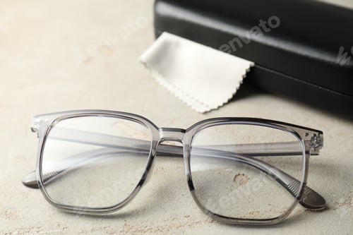 Preview: Stylish glasses and case on light table, closeup