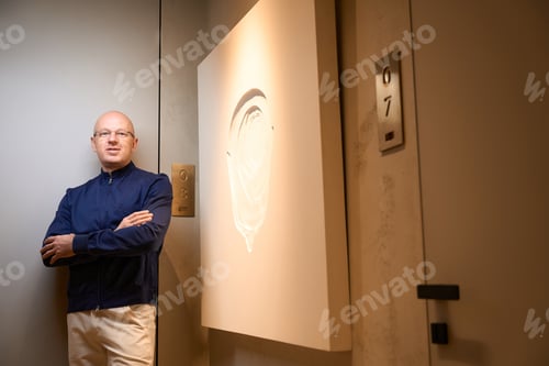 Preview: Man stands in the lobby of a modern building