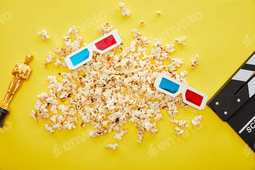 Preview: KYIV, UKRAINE - AUGUST 13, 2019: top view of popcorn, 3d glasses and clapper board with golden Oscar