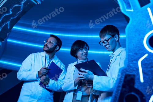 Preview: creative teamwork, indian scientist thinking on invention near talking colleagues in innovation hub