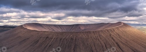 Preview: Panoramic view of a volcanic crater under dramatic skies.