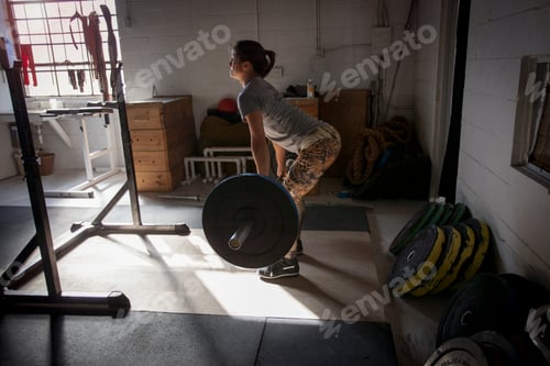 Preview: Crossfitter lifting barbell in gym