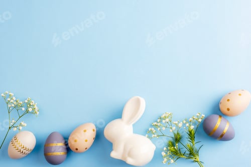 Preview: Easter eggs, flowers and ceramic bunny on blue background. Easter concept.