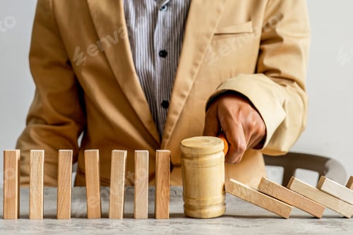 Preview: Businessman Uses Wooden Gavel To Stop Falling Dominoes