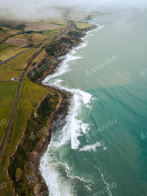 Preview: Picturesque landscape of an ocean shoreline featuring lush green shrubbery