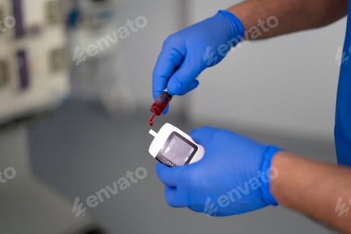 Preview: Doctor measuring blood glucose level with portable glucose meter in hospital