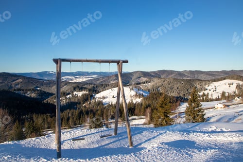 Preview: a snow covered mountain with a wooden swingset on top