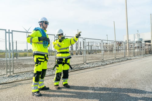 Preview: Wind turbine or windmill worker or technician woman stand with co-worker man near small power plant