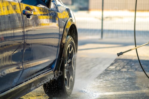 Preview: Closeup of male driver washing his car with contactless high pressure water jet