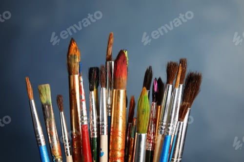 Preview: Different paint brushes on color background, closeup