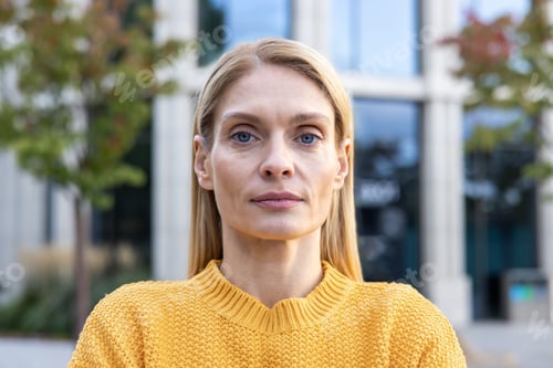Preview: Confident woman in yellow sweater outdoors in autumn