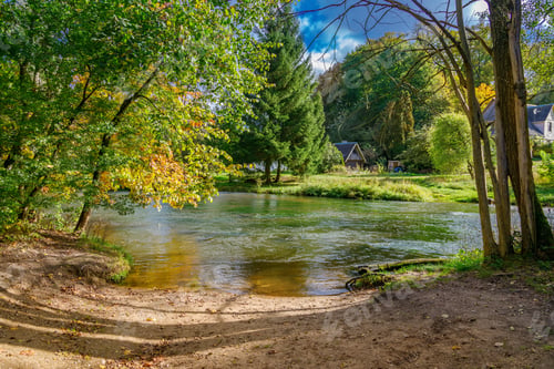 Preview: Peaceful river flowing through autumn landscape with colorful trees and rural houses