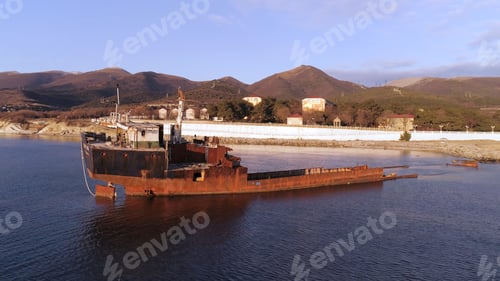 Preview: Aerial for shipwreck on a beach with blue, cloudy sky and green mountain background. Shot. Wrecked