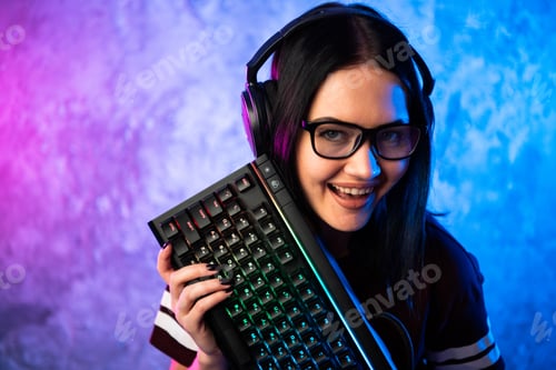 Preview: Young teen gamer wearing glasses standing posing with computer gaming equipment