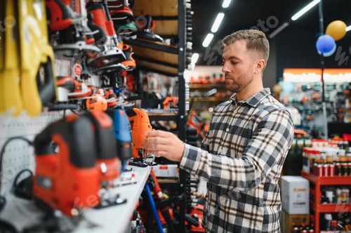 Preview: Man is choosing electric saw in tools store