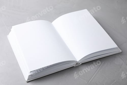 Preview: Open book with blank pages on light grey stone background. Mock up for design