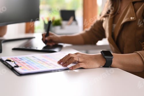 Preview: Young creative woman using graphic tablet and professional computer working for design project.